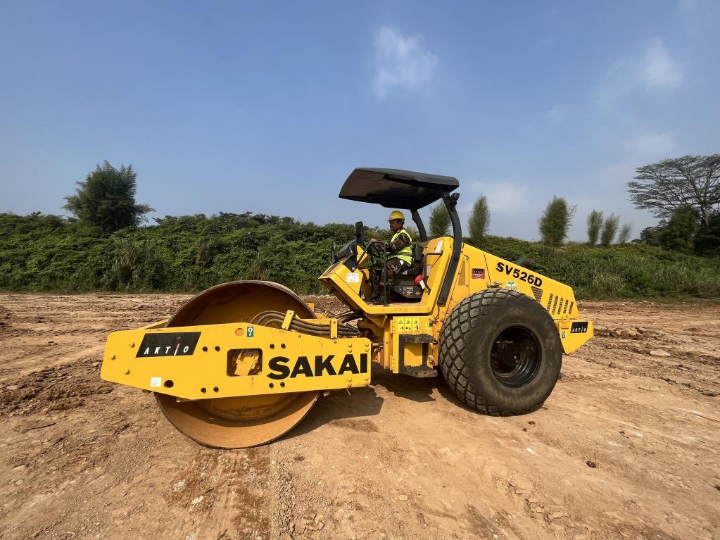 A participant operates heavy machinery on a field