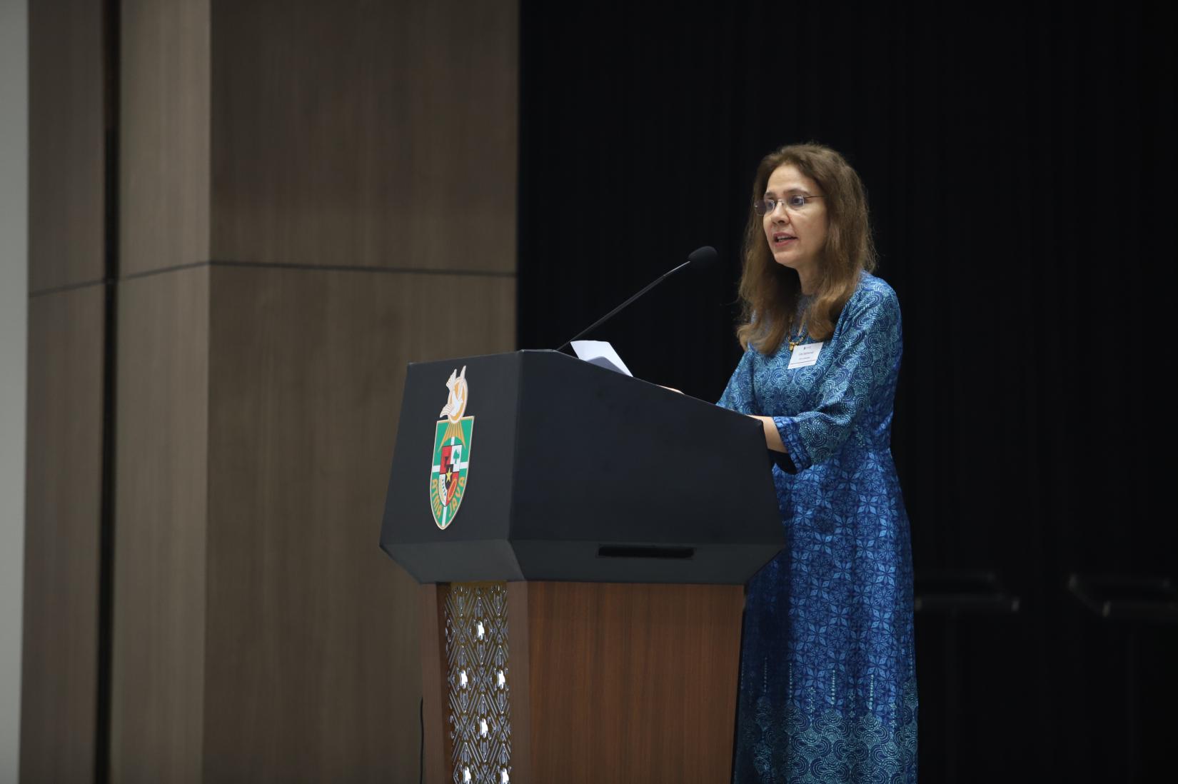 Gita Sabharwal speaking behind a podium