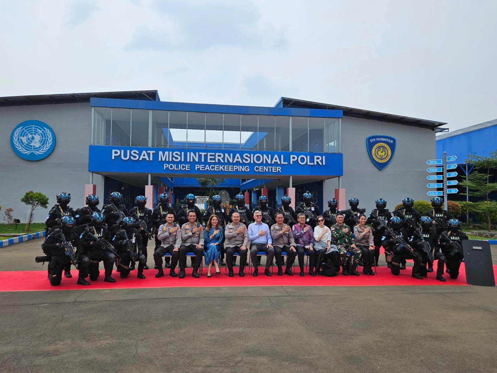 Dozens of people posing in front of a building