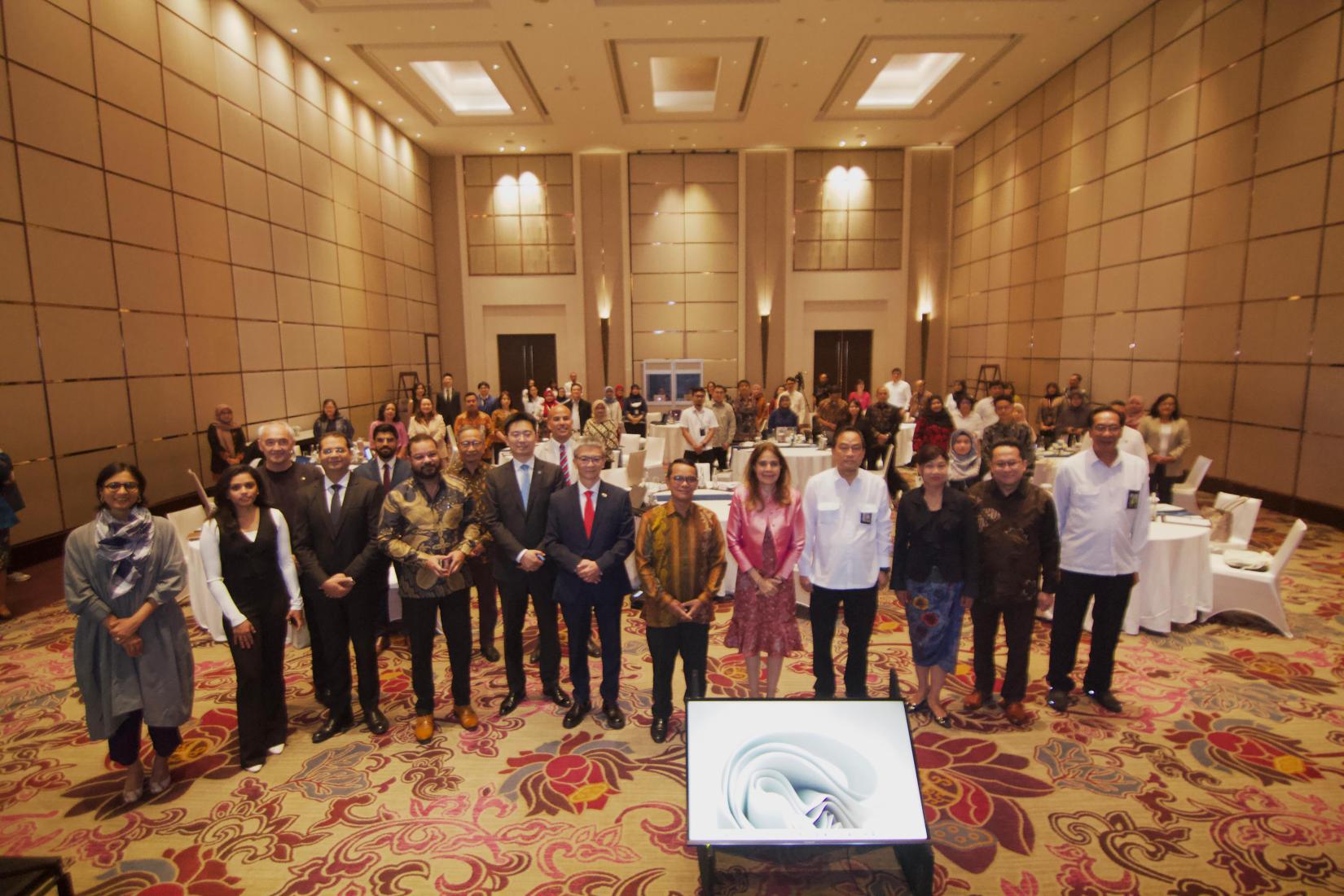 Dozens of people posing in a meeting room