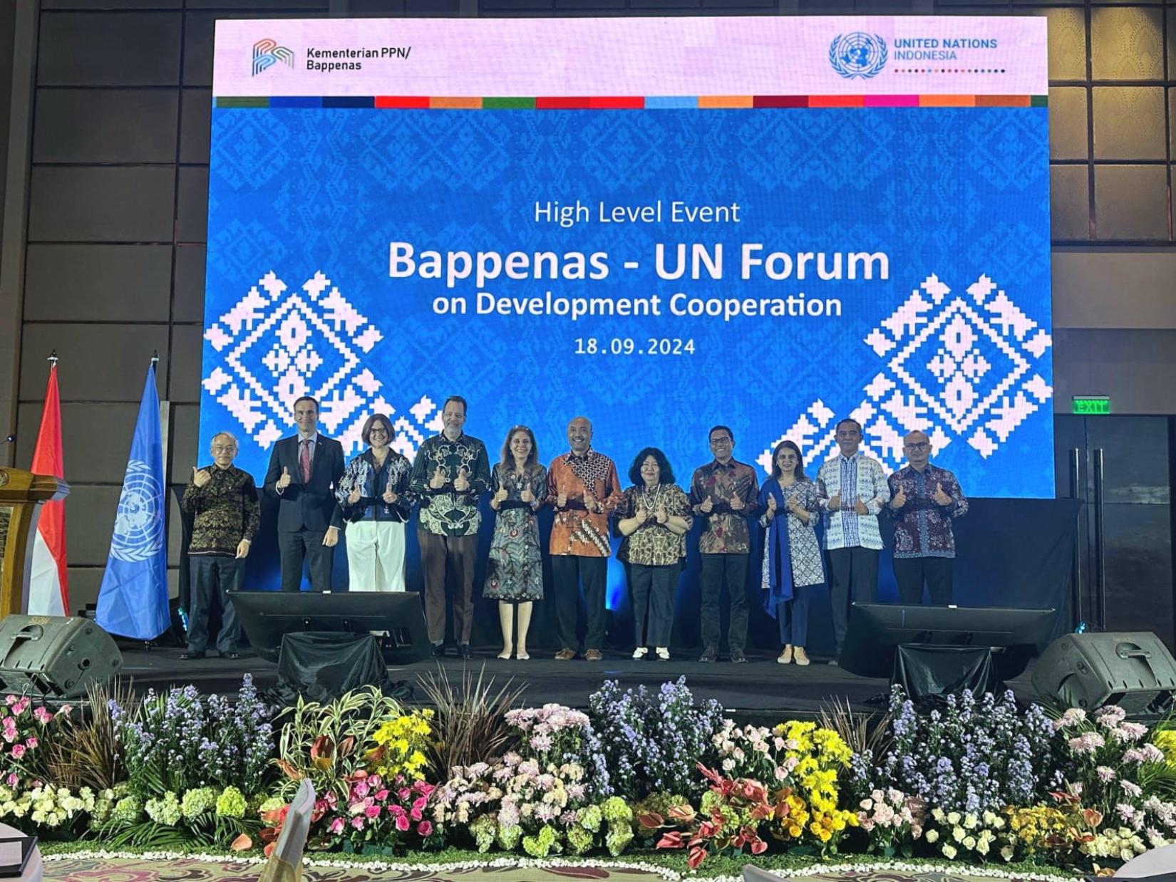 Eleven people representing government, UN agencies, and partners posing on a stage