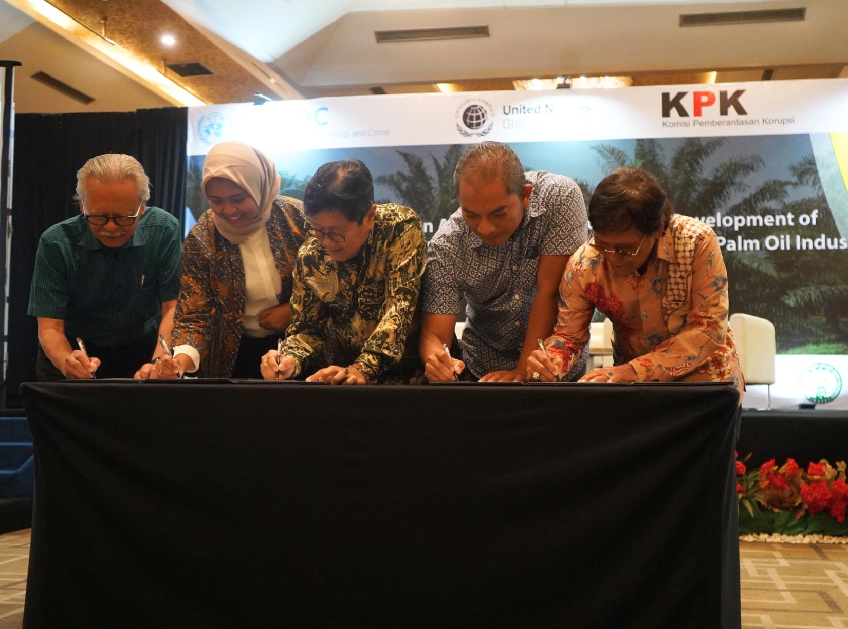 Five people signing a document