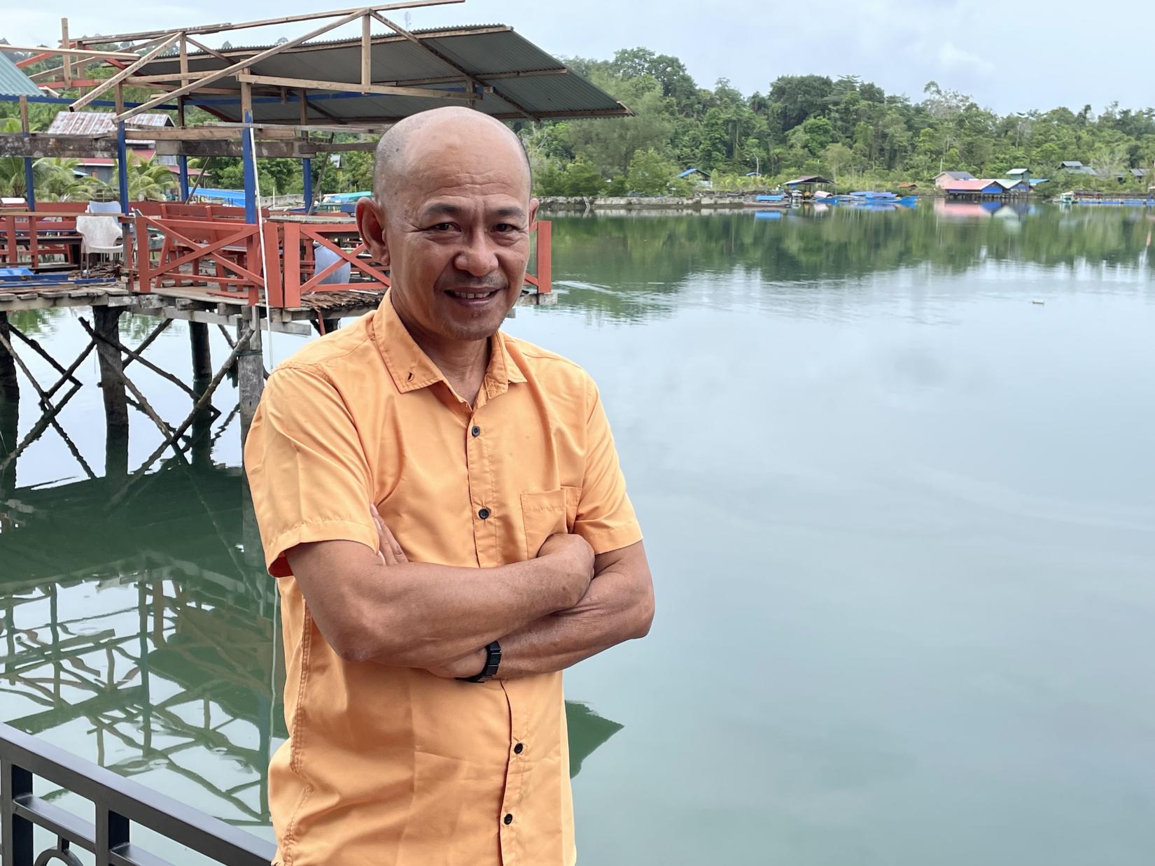 Ahmadi standing by a pier in Simeulue