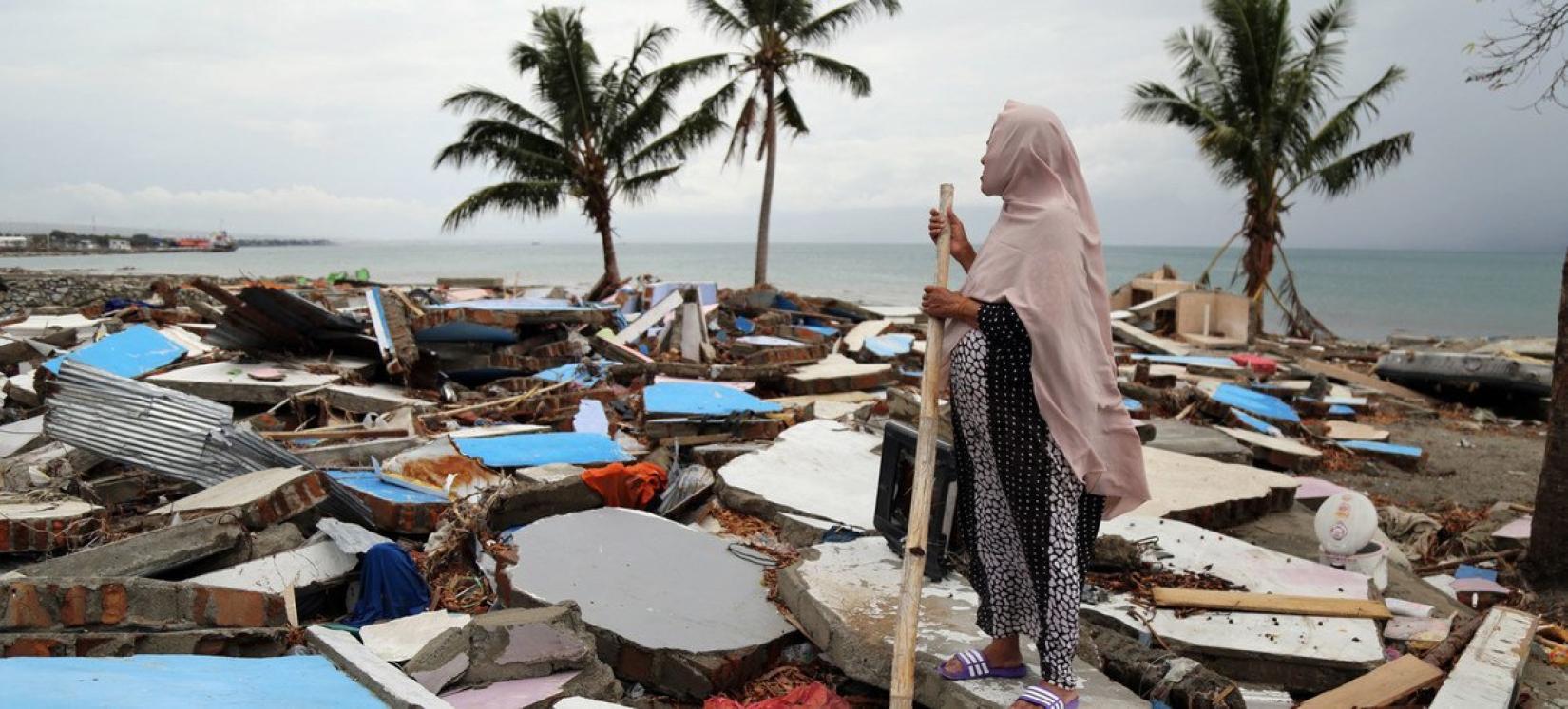 A woman looking at the ruins of buildings