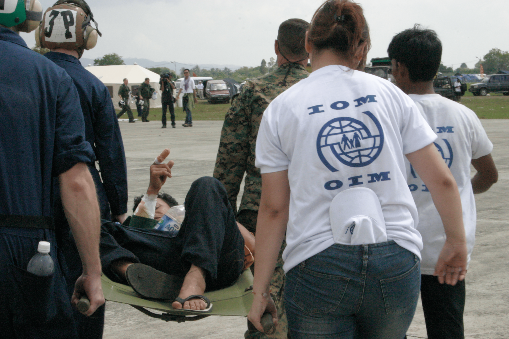 In a coordinated effort to provide immediate assistance, personnels from the International Organization for Migration (IOM) worked with the United States service members to ensure the rapid transportation of a Tsunami survivor. Recognizing the situation's urgency, the team mobilized quickly to facilitate the survivor's transfer to a medical facility where they could receive essential life-saving medical care.