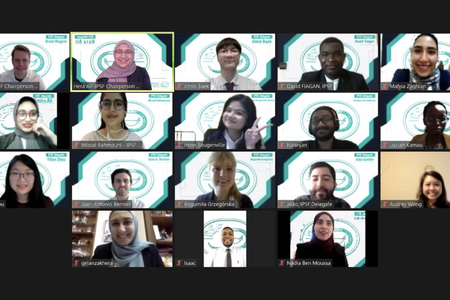 Tangkapan layar dari rapat online yang dihadiri delapan belas peserta sedang tersenyum ke layar.