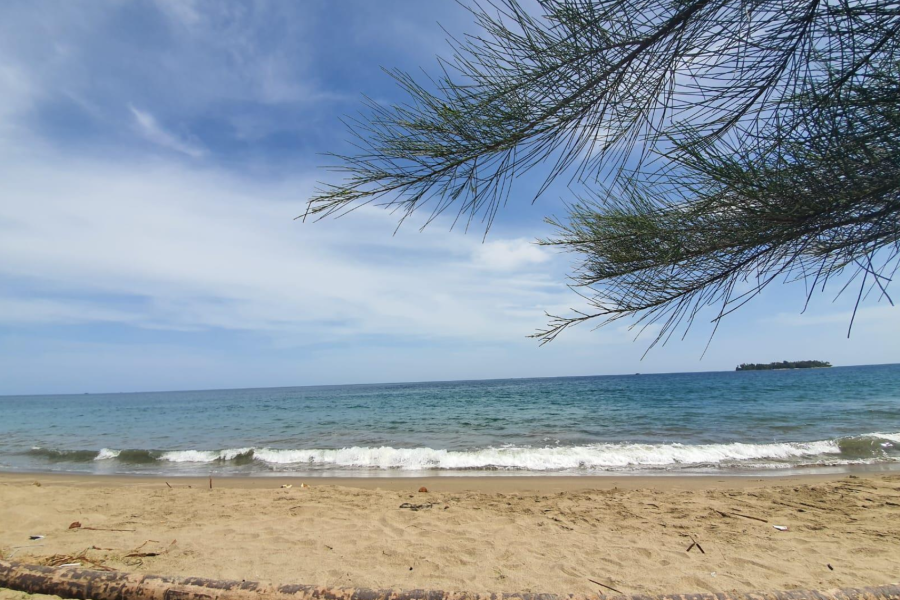 The beautiful landscape of Aceh beach, with calm waves and a bright blue sky.