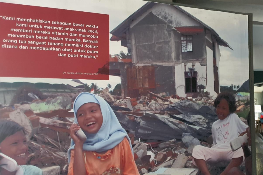 One of the documentations from Aceh Tsunami depicting three little girls smiling brightly on top of building ruins is showcased at the Aceh Tsunami Museum.
