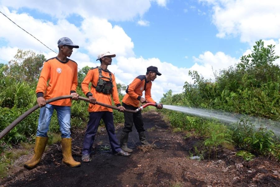 Volunteer firefighters in Limbung keep the peatland moist using water from the canal. This limits damage if a wire were to break out.