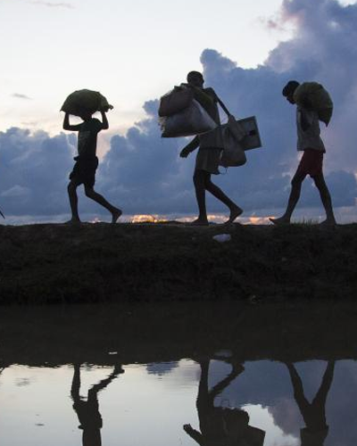 Rohingya refugees fleeing conflict and persecution walk towards the Kutupalong refugee settlement.